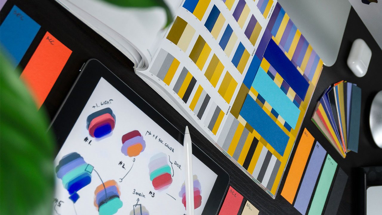 Colour swatches, palette chips and logo sketches on a designer's desk