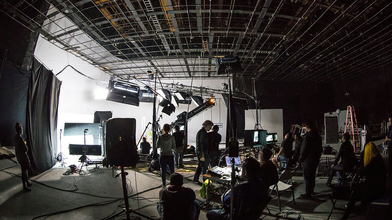 Film crew and lighting rig working on a production set